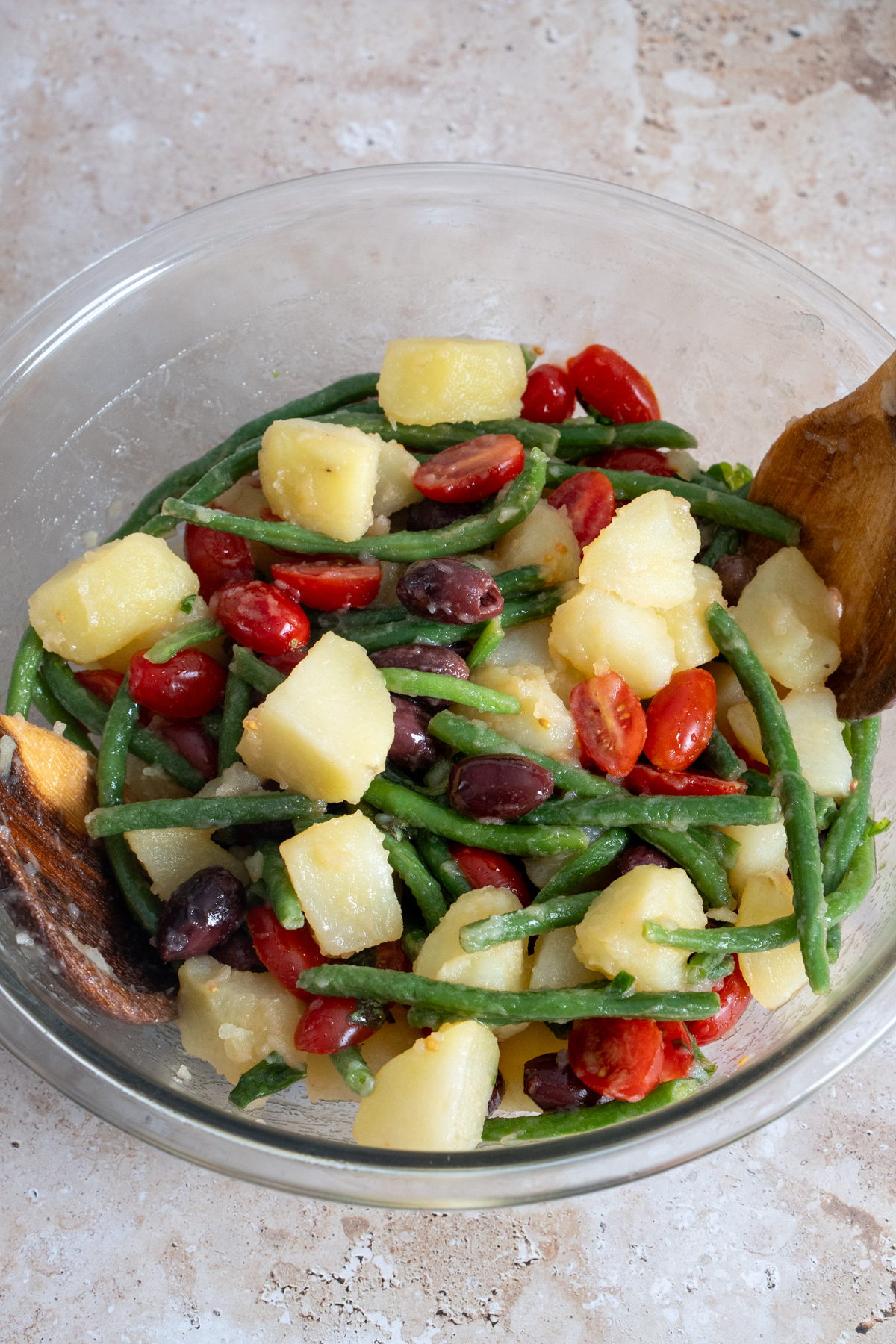 Potato salad with green beans, tomatoes and olives in a bowl