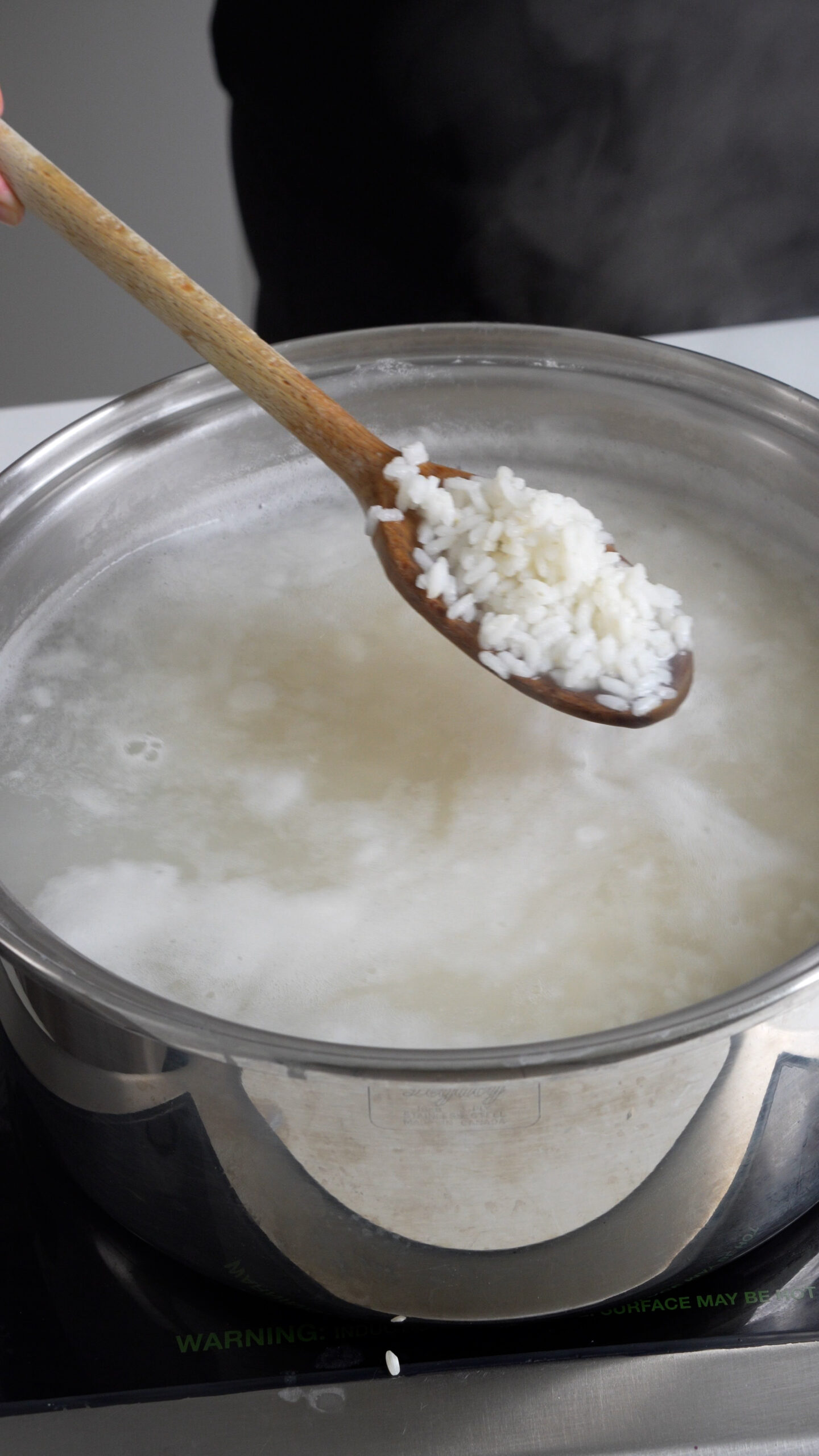 Cooked rice on a wooden spoon
