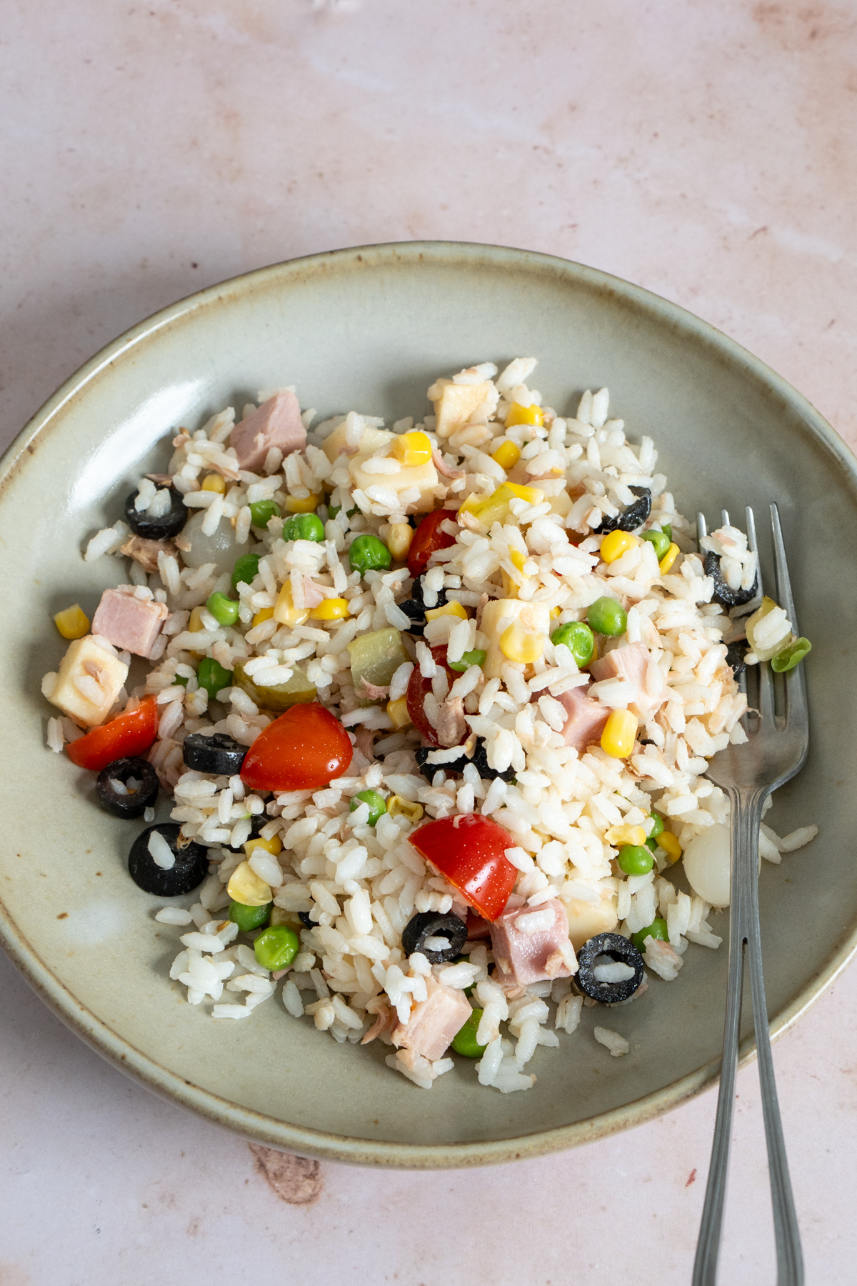 Italian rice salad in a dish with a fork to the side