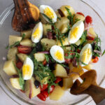 Italian Potato Salad with Arugula topped with hard boiled eggs